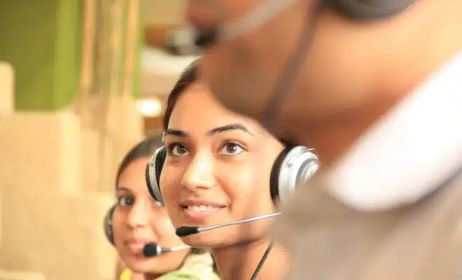 woman in black headphones holding black and silver headphones